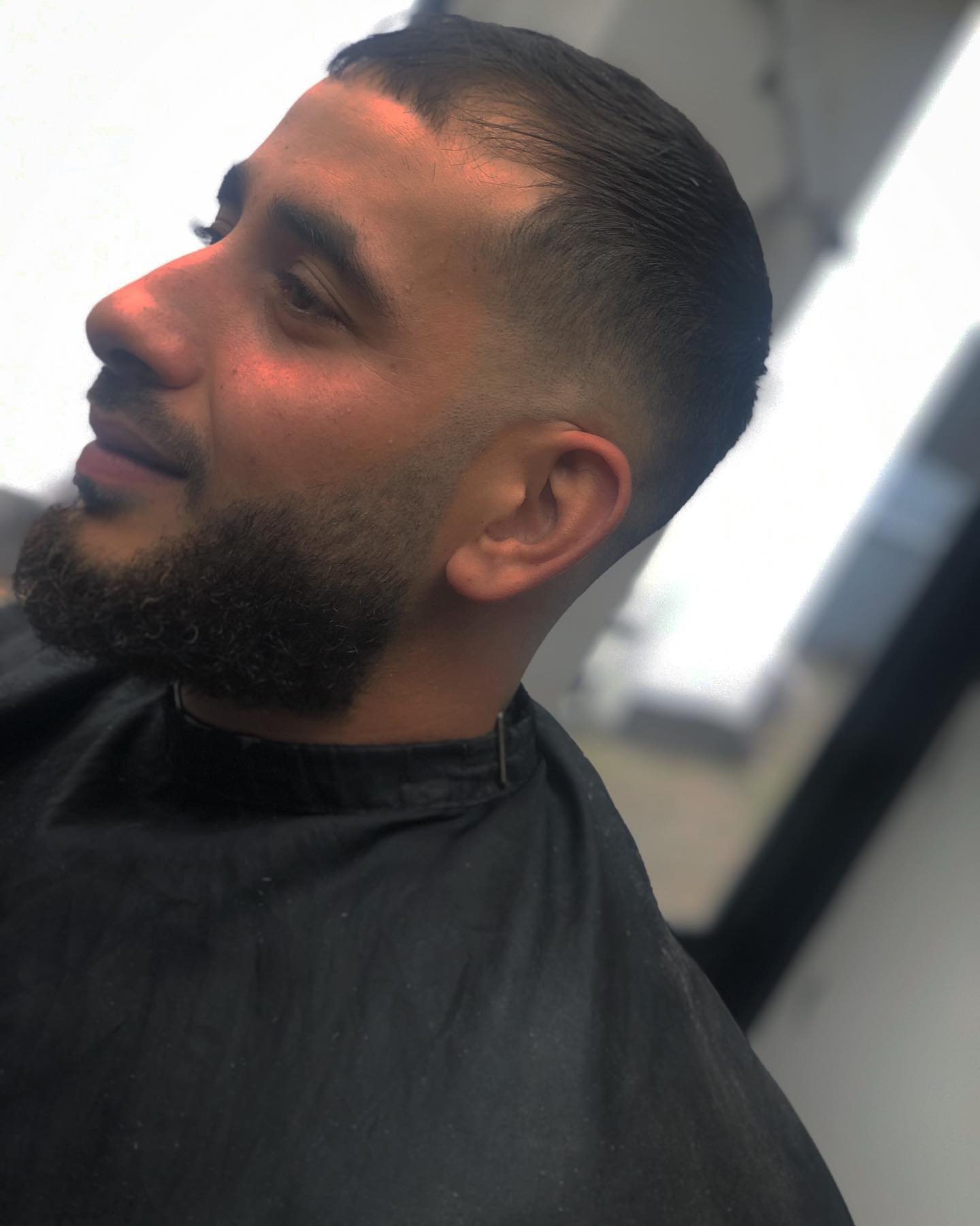 Klant met baard en skin fade, van opzij